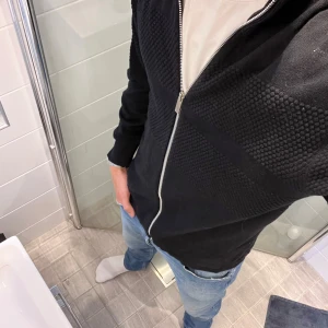 Svart stickad kofta med dragkedja - Stilren zip kofta😊Svart stickad kofta med snyggt strukturmönster över bröstet och ryggen. Hög krage och hel dragkedja framtill ger en clean look. Långärmad och passar perfekt till jeans. Enkel att slänga på sig när det är lite kyligt ute. 349kr😊