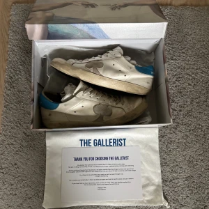 Vita sneakers från The Gallerist - Tja! Säljer dessa riktigt snygga skor ifrån The gallerist | Storlek~43 | Färg~Vit/blå | Dom tillverkas inte längre så sjukt limiterade! Hör av er vid minsta fundering🙌