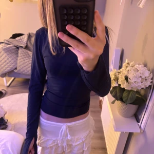 Mörkblå långärmad tight tröja - Säljer en mörkblå långärmad tröja med tight passform. Tröjan är enkel och stilren, med långa ärmar. Med en slits längst ner på ärmarna. 