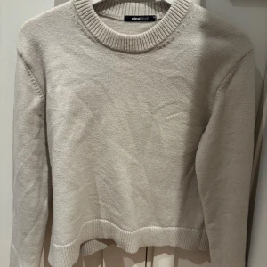 Beige stickad tröja från Gina Tricot - Supermjuk beige stickad tröja från Gina Tricot i storlek XS. Tröjan har rund halsringning, ribbade muddar och en klassisk, enkel design som är lätt att matcha. Perfekt för lager-på-lager och chill dagar.