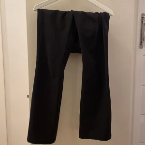 Svarta kostymbyxor från BikBok - Snygga svarta kostymbyxor från BikBok original pris 500, storlek 34 men är mindre i storlek. Byxorna har raka, vida ben och hällor för bälte. Perfekta för en clean och stilren look. Materialet känns mjukt och följsamt, vilket gör dem bekväma hela dagen.