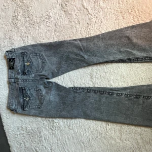Grå bootcut jeans från True Religion - Säljer ett par grå jeans från True Religion i storlek 26.🫶🏼