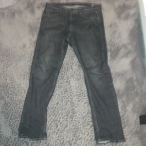 Svarta Replay jeans slim fit - Säljer ett par svarta jeans från Replay med klassisk femficksdesign och diskreta detaljer. Jeansen har en slim passform och raka ben, tillverkade i mjukt denimtyg. Perfekta för dig som gillar en stilren look med lite edge.