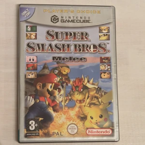 Super Smash Bros Melee - Nintendo GameCube  - Kasta dig in i kaoset med Super Smash Bros Melee till GameCube! Spela som dina favoritkaraktärer från Nintendo-världen och utmana vänner i episka fighter. Perfekt för dig som gillar action, tävling och klassiska spelikoner. En riktig partyhöjdare för alla åldrar!