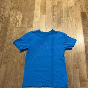 Blå Stone Island t-shirt i bomull - Snygg blå t-shirt från Stone Island med tryckt logga på bröstet. Klassisk rund hals och korta ärmar. Tillverkad i mjuk bomull som är skön att ha på sig. Perfekt för dig som gillar streetwear och vill sticka ut lite extra. Köpt för 1199 använd några gånger 