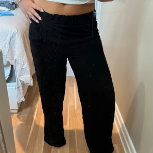 Svarta vida byxor från 157 - Säljer ett par svarta byxor från 157 med elastisk midja och vida ben. Byxorna har en enkel och clean look, perfekta att styla med crop top eller hoodie. Materialet känns lätt och skönt mot huden. Passar dig som gillar loose fit och vill ha något bekvämt men ändå snyggt.