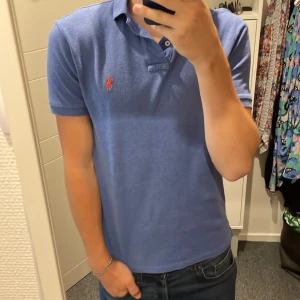Blå Polo Ralph Lauren t-shirt slim fit, Stl S - Blå Ralph lauren piké, perfekt för stil i vardagen men även på golfbanan. Tröjan är i S, Custom Slim Fit. 