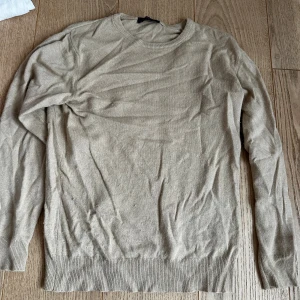 Beige kashmirtröja från Cashmere Collection - Säljer en supermjuk och stilren beige kashmirtröja från Cashmere Collection, Made in Italy. Tröjan har rund halsringning, ribbade muddar och lång ärm. Perfekt för dig som gillar klassisk och clean stil.