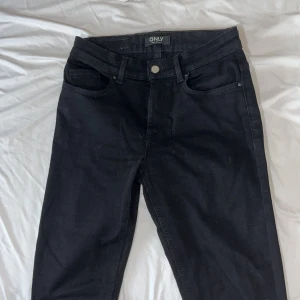Svarta bootcut jeans från ONLY - Svarta jeans från ONLY med klassisk ficka och smal passform. Jeansen har normal midja och är tillverkade i stretchigt bomullsmaterial för en bekväm känsla. Snygga och enkla att matcha med allt i garderoben. Använts fåtal gånger!!