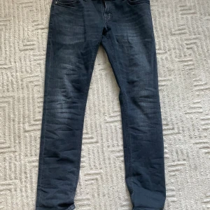 Slim fit nudie jeans - Säljer nu mina asfeta nudies i sällsynta färgen black/grey som då är en mix på svart och grå som blir ljusare och ljusare ju mer de används, perfekt för att göra de personliga! Storlek 32/32, nyskick, modell Tight long john. Vid fler frågor eller funderingar är det bara att skriva!
