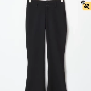 Svarta bootcut byxor från Gina Tricot - Snygga svarta bootcut-byxor från Gina Tricot i storlek M. Byxorna har låg midja, två knappar framtill, bälteshällor och bakfickor med knapp. Materialet är mjukt och stretchigt, perfekt för en trendig Y2K-look. Säljer med prislapp pga försmåa