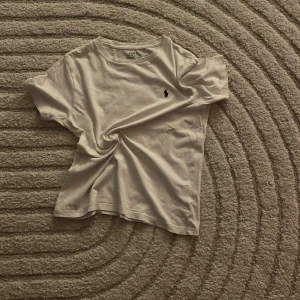 Vit t-shirt från Polo Ralph Lauren - Vit t-shirt från Polo Ralph Lauren med marin blå logga, denna tröja är skit snygg fast den har en pytte liten fläck man ej ser.