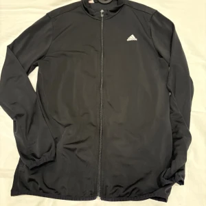 Svart adidas träningsoverall - Hej säljer en svart adidas tracksuit i storlek S-M. Säljer denna fina dress eftersom jag tyvärr växt ur den. Endast andvänd ett fåtal gånger vilket man ser på skicket på dressen. Byxor ingår!!