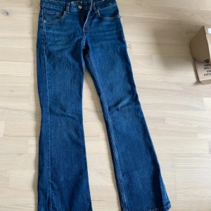 Blå bootcut jeans Mira W24 L32 - Snygga blå jeans från i bootcut-modell. . Tillverkade i jeansmaterial som ger en tidlös look och passar perfekt till sneakers eller boots. Nästan oanvända från Bikbok