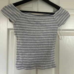 Gråvit randig offshoulder topp från New yorker  - Hej jag säljer en grå och vit randig offshoulder topp från New yorker i storlek S. 💕
