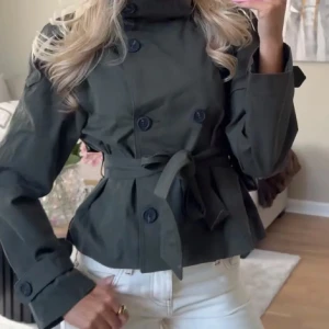 Trenchcoat Bershka - Den populära trenchcoaten ifrån Bershka i storlek S. Helt oanvänd och därav i nyskick.
