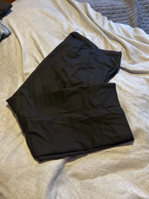 Svarta kostymbyxor från H&M, high waist - Säljer ett par svarta kostymbyxor från H&M med hög midja och straight fit. Byxorna har dragkedja och knapp framtill samt justerbar midja. Perfekta till en clean och stilren look.