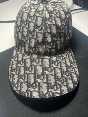 Mönstrad keps dior - Säljer en dior keps som har andvänts måttligt, fortfarande i bra skick