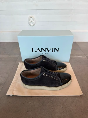 Mörkblå Lanvin skor - Säljer mina mörkblå Lanvin skor med glansig captoe. Skorna är i storlek 41, men passar även 41,5. Skicket är mycket bra (8/10). Box och dustbag ingår. Skriv för fler bilder eller ifall du har några generella frågor!