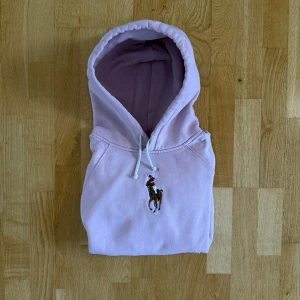 Rosa Ralph Lauren Hoodie - Säljer en väldigt snygg och unik Rosa Hoodie från Ralph Lauren. Hoodien är i bra skick och är i strl S fast skulle uppskatta att den sitter mer som en Xs. Hör gärna av er vid frågor elr funderingar!!