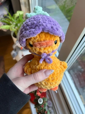 Virkad anka med lila blomhatt - Supersöt gul anka med blomhatt.💜  OBS:  !Dessa innehåller säkerhetsögon som inte rekommenderas för barn under 3 år!