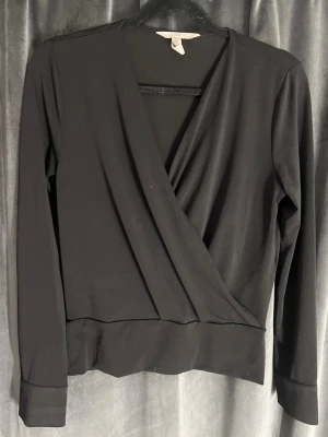 Omlott blus - Svart omlott blus köpt ifrån h&m, använd men fortfarande i fint skick! Den har guldknappar vid ärmarnas slut och sitter lite tajtare vid midjan. Storlek xs köpt för 299, hör av dig ifall du vill ha fler bilder eller funderar på något 💞