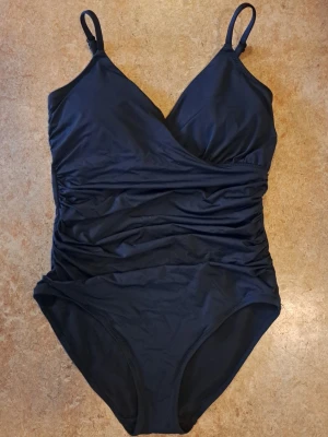 Svart baddräkt strl 38 - En baddräkt från Lindex med justerbara axelband. Använd 1 gång, men passar inte längre..