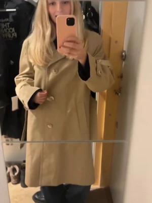 Beige trenchcoat från Strellson - Lång beige trenchcoat från Strellson. Knappt använd ❤️ Strl L så att den är lite oversized på mig som vanligtvis bär S! 
