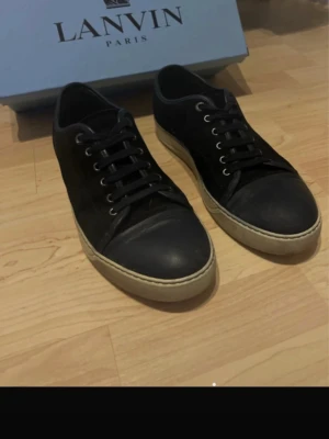 Svarta sneakers från Lanvin - Lanvin sneakers i svart med rund tå och vit platt sula. Skorna har snörning och en stilren design med svart ovandel i mocka och skinn.  Bra skick som sulan är hel o har sitt mönster💯 ALLT OG MEDFÖLJS😊💯Kan acceptera byten som gats o annat hör av er