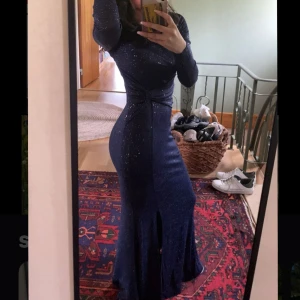 Marinblå glittrig balklänning  - Supersnygg marinblå balklänning från Bubbleroom med glittriga detaljer, lång ärm och markerad midja med twist effekt. Klänningen har ett slits framtill och sitter figurnära. Under klänningen är det även ett extra tyg! Uppsydd längst ner men går att sprätta upp. Köpt för 999kr. Skriv privat för fler bilder eller funderingar 💓