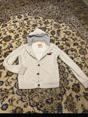 Hollister cardigan - Fet hollister cardigan som är jätte sällsynt och inga tydlig tecken på användning Storlek längd 61cm axel till axel 41cm Prisen kan diskuteras vid snabbaffär Va inte rädda för att ställa frågor!!!