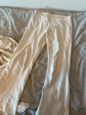 Brandy Melville mjukisar - Säljer ett par vita mjukisbyxor med bred resår i midjan och snörning framtill. Byxorna har en loose passform och är tillverkade i mjukt bomullsmaterial. Benen är raka och har en enkel, clean look utan detaljer eller mönster. Väldigt oversize i storleken, passar inte alls på mig som är XS. Passar dock i längden (160cm). 