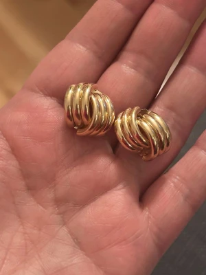 örhängen i guldfärgat rostfritt stål.  - Eleganta och trendiga örhängen i guldfärgat rostfritt stål. Stilren, modern design som passar både till vardag och fest.