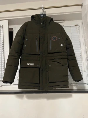 Geographical Norway Kids Winter Jacket – Size 10 Years – Warm & Hooded - Stylish and warm Geographical Norway Expedition winter jacket for kids. Perfect for cold weather – designed to keep children warm, protected from wind and rain. ✔ Size: Kids 10 years ✔ Color: Dark green / khaki ✔ Brand: Geographical Norway ✔ Hooded winter jacket ✔ Warm padding, wind & cold protection ✔ Multiple pockets ✔ Good condition (see photos) Great for school, everyday wear, outdoor activities or winter trips. Feel free to message me if you have any questions 😊 