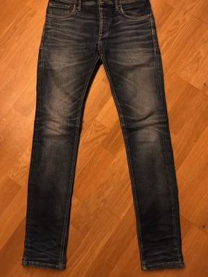 Jack & Jones Slim Fit Jeans Blå 27/32 - Slim fit jeans från Jack & Jones i en snygg tvättad blå färg. Klassisk femficksmodell med smal passform och normal midja. Jeansen har slitningar och kontrastsömmar för en cool look. Tillverkade i mjukt bomullsmaterial för skön känsla.