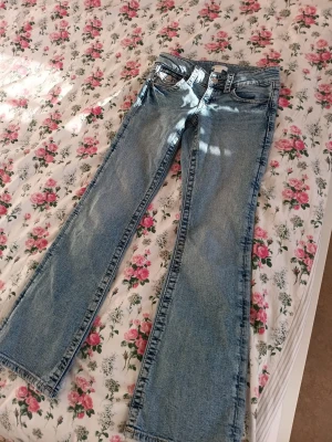 Blå bootcut jeans med fickdetaljer - Snygga ljusblå bootcut jeans med klassisk femficksdesign och coola ficklock bak. Jeansen har låg midja och är gjorda i mjukt denim-material. ⭐️ Knappt använda. Från Gina tricot storlek 146! Endast 150 kr, passa på att fynda!👖💗