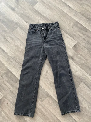 Svarta raka jeans från Weekday - Säljer ett par svarta jeans från Weekday. Jeansen har raka ben, materialet är slitstark denim och färgen är mörkgrå/svart med lite tvättad look. Perfekt för dig som gillar enkel och clean stil.