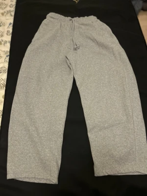 Grå mjukisbyxor från Bershka - Säljer ett par grå mjukisbyxor från Bershka i storlek S. Byxorna är väldigt baggy och har dragsko i midjan samt raka ben. Tillverkade i mjukt bomullsmaterial. Passar både killar och tjejer.