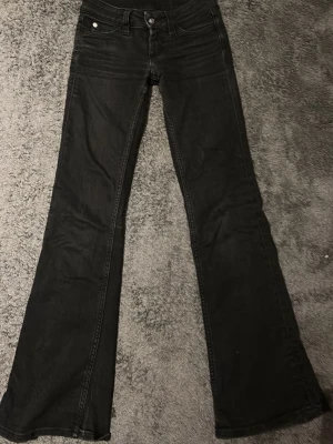 Svarta bootcut jeans från Weekday  - Säljer ett par svarta jeans från Weekday   Det är Cheap Monday jeans med bootcut-snitt och klassisk femficksdesign. Jeansen har en låg midja och är tillverkade i mjukt denim-material. Perfekta för dig som gillar en retro vibe och vill ha ett par jeans som sticker ut lite extra. Säljer pga att dom är förkorta 