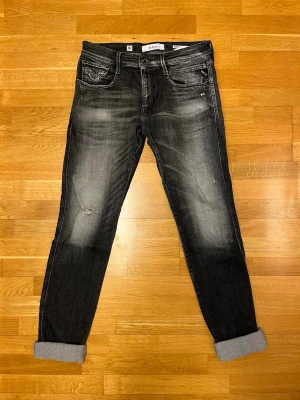 Replay Anbass svarta slim jeans - Svarta Replay Anbass jeans i slim fit med snyggt tvättad look och lite stressningar. Jeansen är gjorda i stretchig denim och har skön passform. Storleken är 33w 36l. 