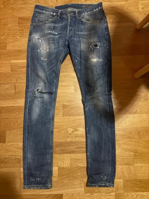 Dondup (George) jeans - Blås Dondup (George) jeans. Det finns ett hål i skrevet. Modellen är 180 cm.