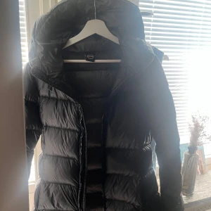 Svart vinterjacka från Colmar - Snygg svart vinterjacka från Colmar med hög krage och huva. Jackan har quiltad design, dragkedja framtill och Colmar-logga på ärmen. Perfekt för kalla dagar och riktigt skön att bära. Har haft den i en vinter så den är i fint skick inga smink fläkar o.s.v. Dock! Har jag en gång ramlat  med jackan så den är lappad på en arm men som inte syns då det är fixat hos skräddaren. köpt för originalpriss 6000kr men säljer för 3000kr! Pris kan även diskuteras! Rekommendation gå upp en storlek 