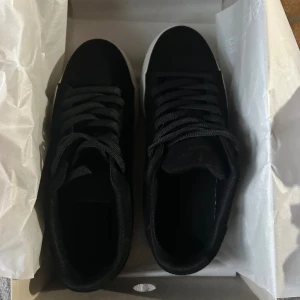 Svarta sneakers Selected Homme - Snygga svarta sneakers från Selected Homme med vit, platt sula och klassisk rund tå. Ovandelen är i mocka och skorna har svarta snören. Perfekta för en stilren och clean look, passar till det mesta i garderoben. Använd en gång små fläckar men enkelt allt tvätta bort!!☺️(nypris 1050kr)