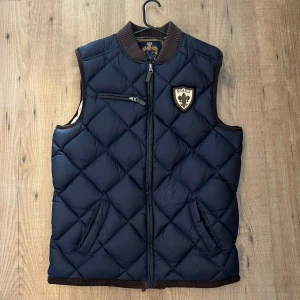 Morris väst  - Säljer denna fina dunvästen från Morris. Fint skick har inga skador. Storlek L! Vid frågor är det bara att kontakta mig😀 