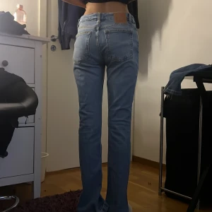 Slim split jeans från Never Denim - Ljusblå jeans från Never Denim med slim fit och raka ben. Klassisk femficksmodell med dragkedja och knapp framtill. Modellen heter Slim Split och har en normal passform. Dessa är lågmidjade och har en slit nere vid benen. Modellen på bilden är 163 centimeter lång ALDRIG ANVÄNT, originalpris 529kr (PRIS KAN DISKUTERAS)!!!