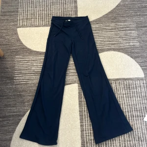 Mörkblå vida byxor från Bershka - Mörkblå vida byxor från Bershka med snörning i midjan och coola stjärndetaljer i nitar på bakfickorna. Byxorna har en skön loose fit och är perfekta för dig som gillar en avslappnad men trendig stil.