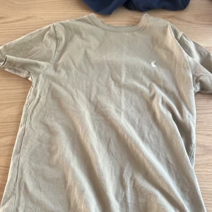 Beige t-shirt från Ralph Lauren - Snygg beige t-shirt från Ralph Lauren med klassisk passform och liten broderad logga på bröstet. Tillverkad i mjuk bomull och har rund halsringning samt korta ärmar. Perfekt för en clean och enkel stil.