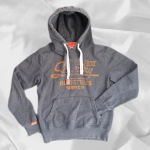 Superdry Hoodie - Snygg superdry hoodie i storlek M – enkel att matcha och skön att bära. Ett stilrent val, noggrant utvalt med omsorg av AM Clothing.  📩 Frågor? Hör gärna av dig! 📲 Följ oss här på Plick för fler uppdateringar. ♻️ Tack för att du handlar mer hållbart med AM Clothing!