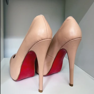 Beige Louboutin klackar - Säljer ett par ikoniska klackskor från Christian Louboutin i beige skinn med klassisk röd sula. Jag har bara använt dem en gång, dem är i strl 37