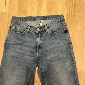 Blå jeans från Weekday Twig - Klassiska blå jeans från Weekday, modell Twig. Jeansen har raka ben, fem fickor och normal passform. Tillverkade i bomull med snygg tvättad look och detaljer i kopparfärg. Perfekta för en avslappnad stil.